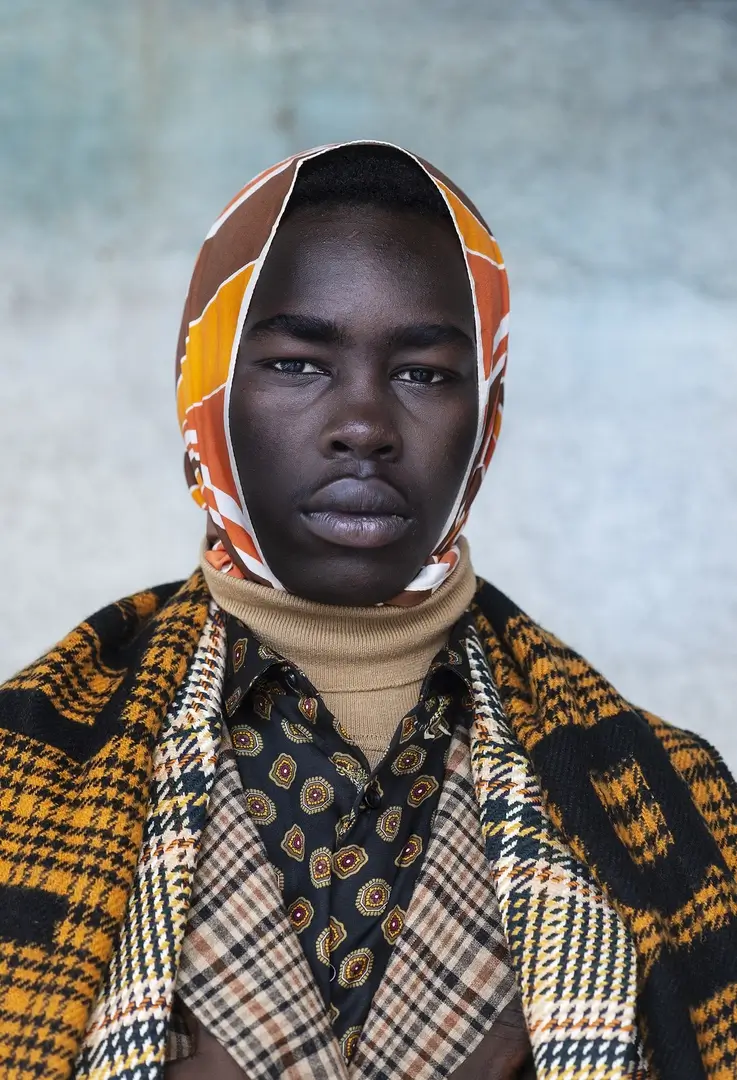 Dark skinned man with scarf shot by Miri Davidovitz
