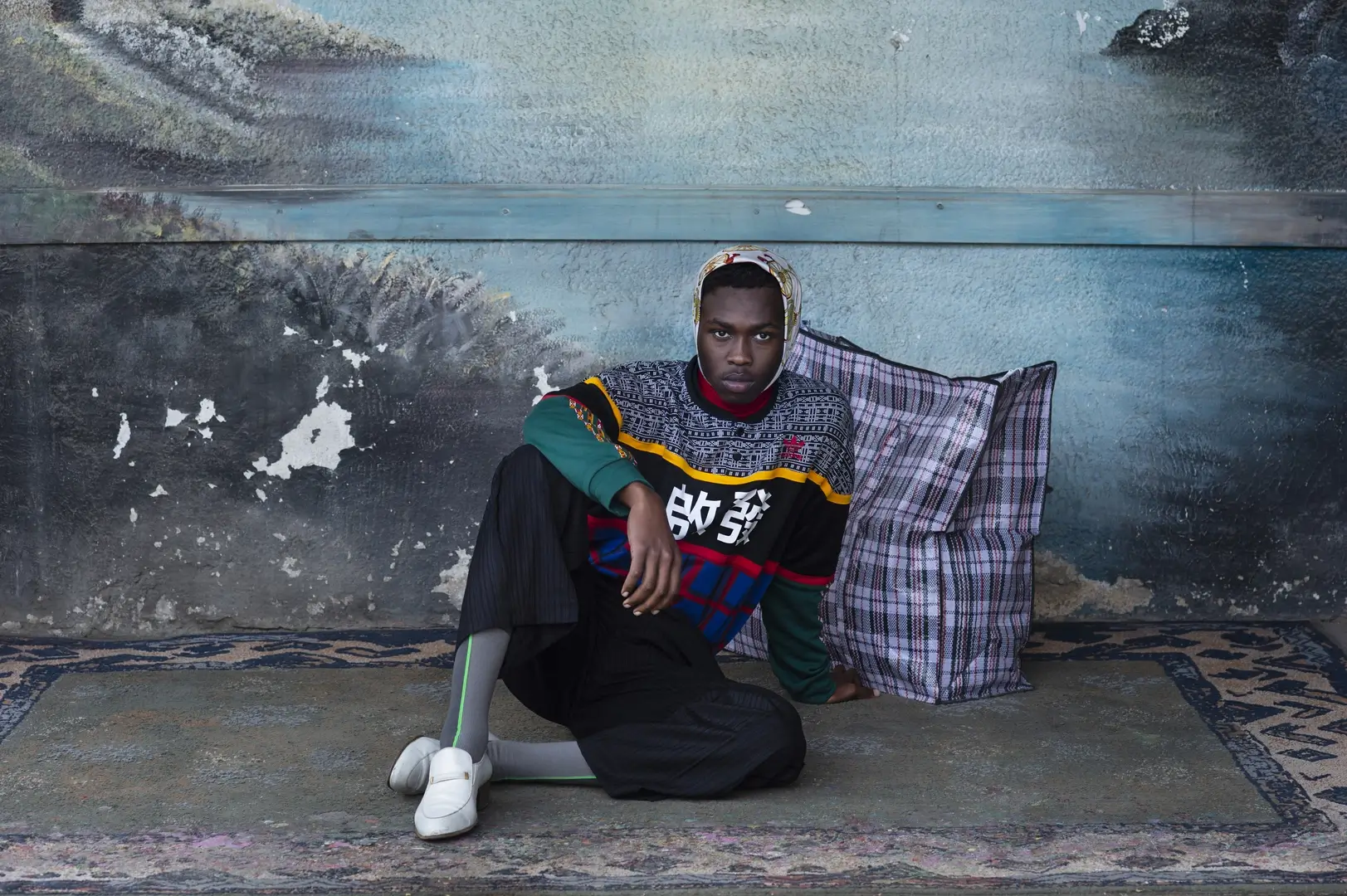 African man photographed sitting on a carpet